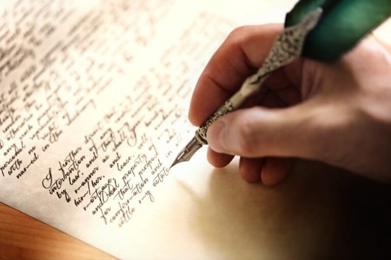 person writing letter with metal quill
